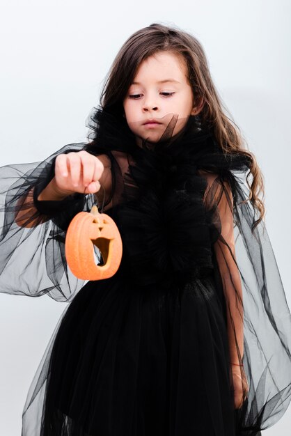 Free Photo front view happy little girl holding a pumpkin