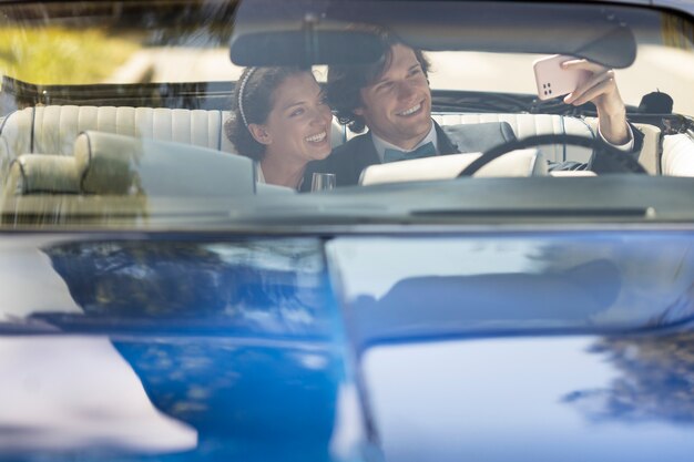 Front view happy married couple in car