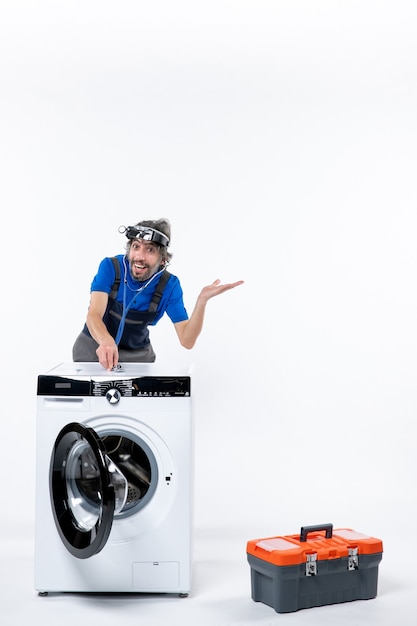 Free photo front view happy repairman with head lamp putting stethoscope on washer on white space