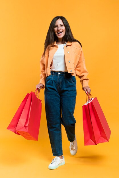 Front view of happy woman holding shopping bags