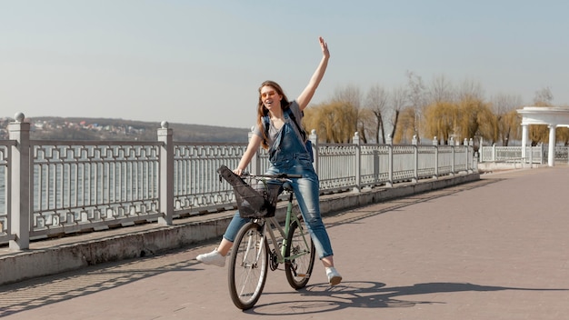 Free photo front view of happy woman riding the bicycle