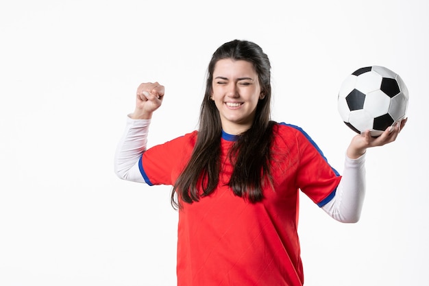 Front view happy young female in sport clothes with soccer ball