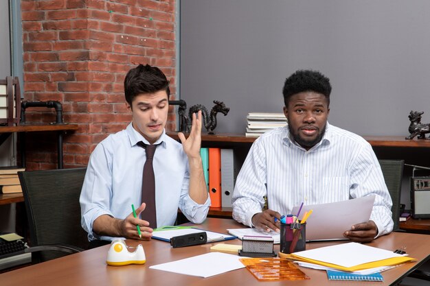 Front view hardworking business partners sitting at desk