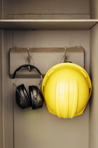 Free Photo front view of headphones and hard hat hanging in a closet