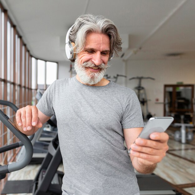 Front view holding smartphone at gym