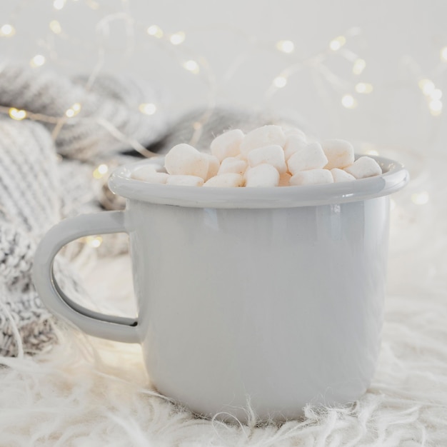 Free photo front view hot chocolate with marshmallows and blanket