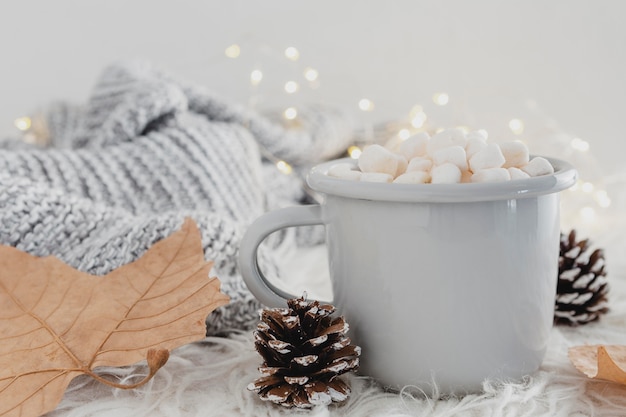 Free photo front view hot chocolate with marshmallows and wool blanket