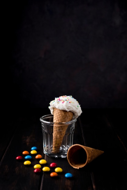 Front view ice cream cone with candy on the table