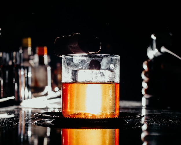 Free photo a front view iced drink inside little glass on the dark bar desk drink juice alcohol water bar