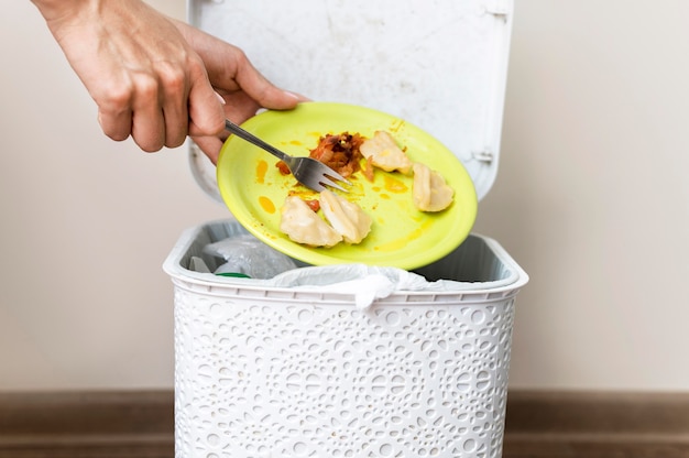 Front view individual throwing leftovers away