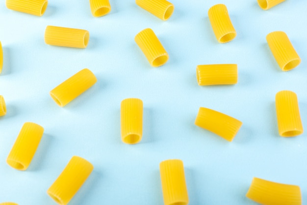 A front view isolated yellow pasta little raw on the blue background food meal spaghetti pasta