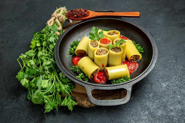 Front view italian pasta with greens tomato sauce and meat inside pan on grey space