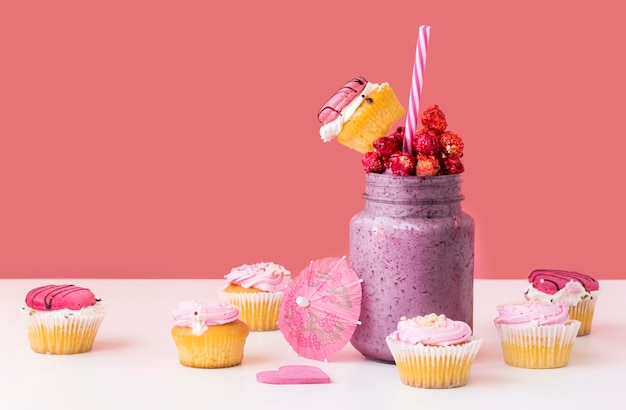 Front view of jar of dessert with fruit and muffins