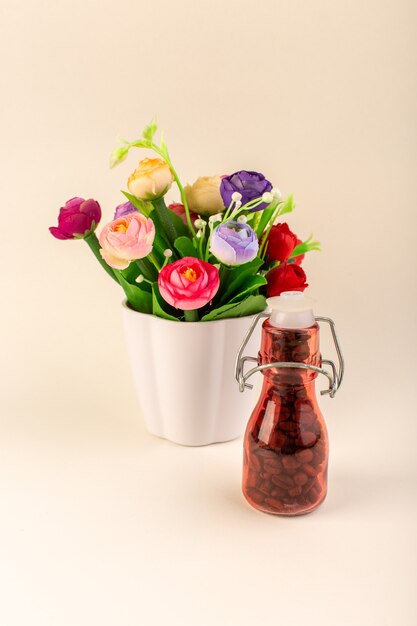 A front view jar with coffee and flowers on the pink table coffee color flower seed