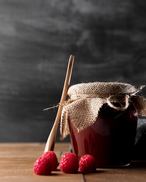 Front view of jar with raspberry jam and fruit