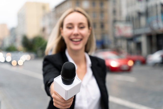 Free Photo front view journalist holding a microphone