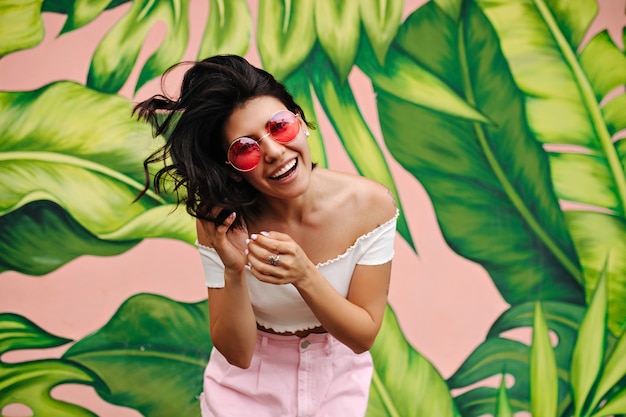 Free photo front view of joyful brunette woman posing beside green graffiti