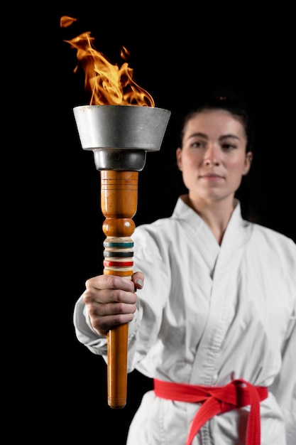 Free Photo front view of karate athlete holding torch