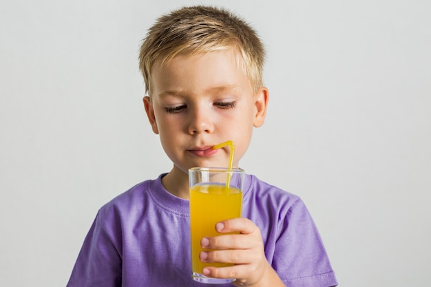 Free photo front view kid drinking juice with a straw