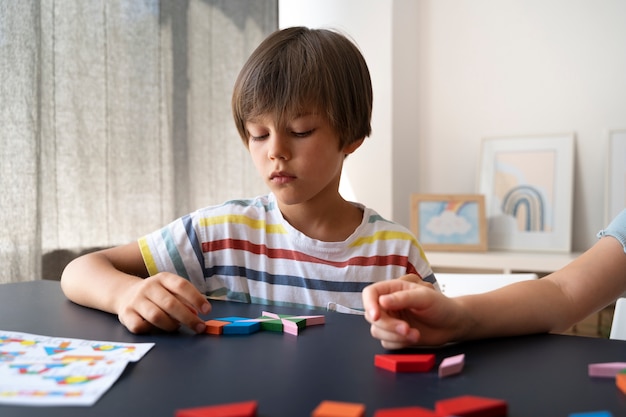 Free Photo front view kid making puzzle on table