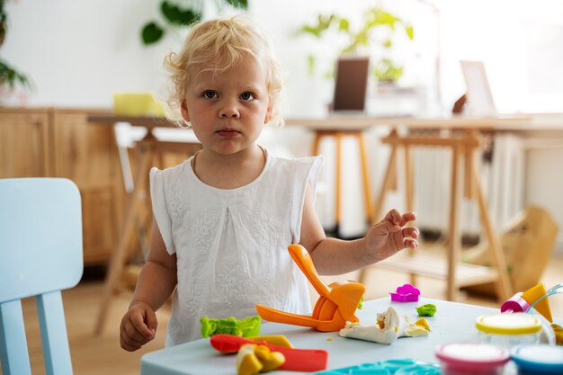 Front view kid with toys indoors