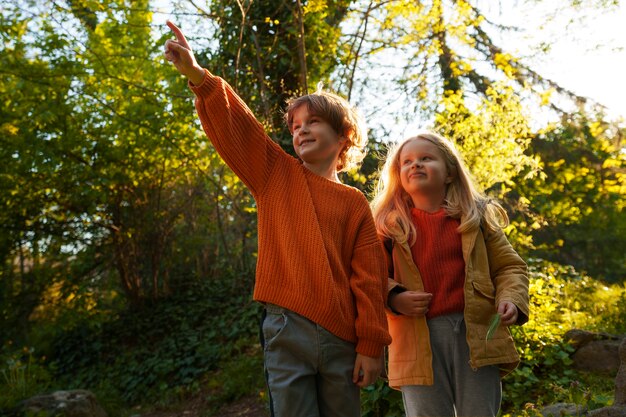 Front view kids exploring nature together