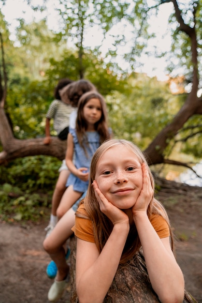 Front view kids sitting on log