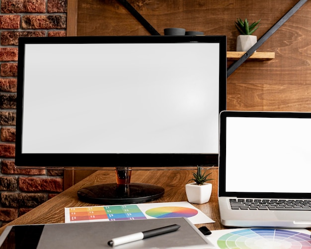 Free photo front view of laptop and computer on office workspace