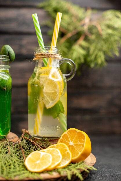 Front view lemonade with feijoa and lemon on wooden board cut lemons on surface