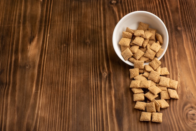 Free photo front view little cookies inside plate on brown wooden desk