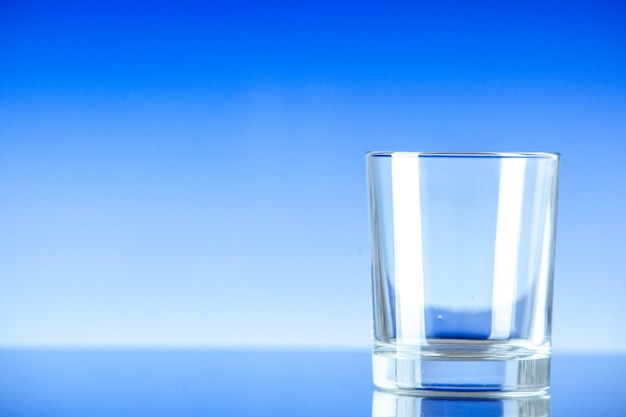 Front view little empty glass on a blue surface