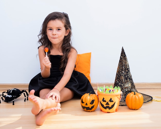 Front view little girl sitting on floor on halloween