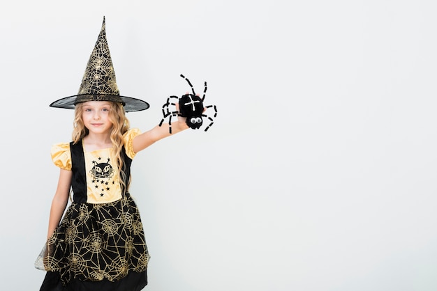 Free photo front view little girl in witch costume with copy space