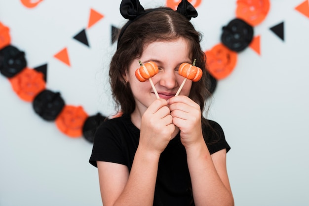 Free Photo front view of a little girl with pumpkin candies