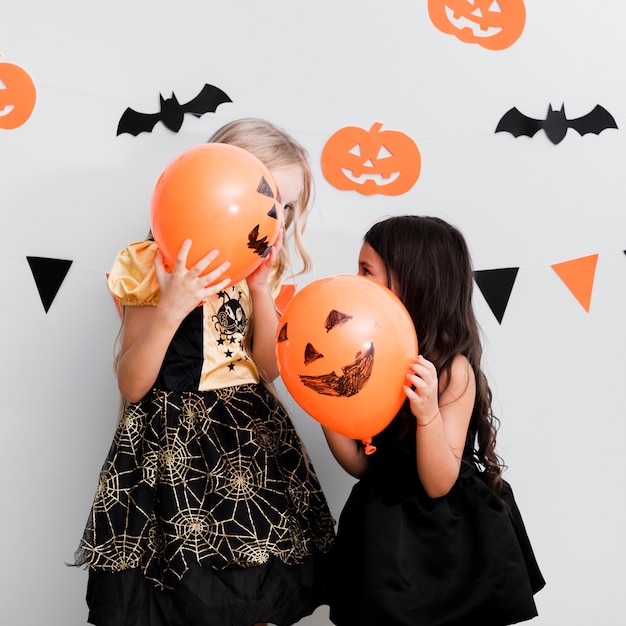 Free photo front view little girls in witch costume for halloween