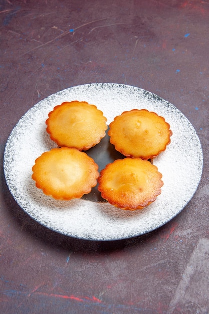 Front view little yummy cakes inside plate on the dark background sweet pie biscuit cookie tea cake