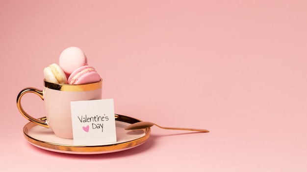 Free photo front view of macarons in golden cup for valentine's day