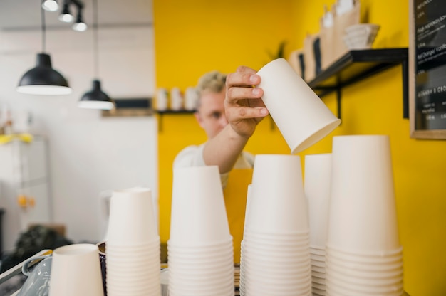 Free Photo front view of male barista with coffee cups