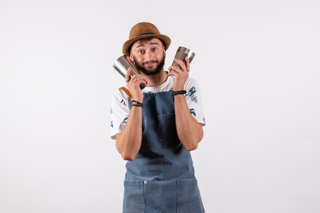 Front view male bartender holding shaker on white wall club night bar alcohol drink job color