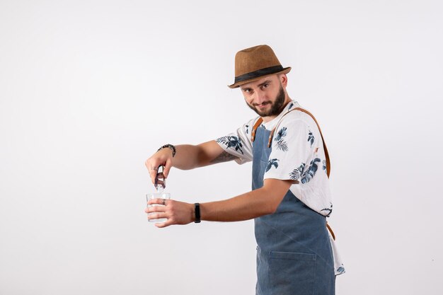 Front view male bartender making a drink on white wall night job club alcohol drinks color bar