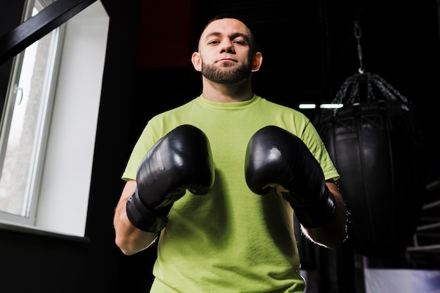 Free photo front view of male boxer wearing protective gloves and t-shirt