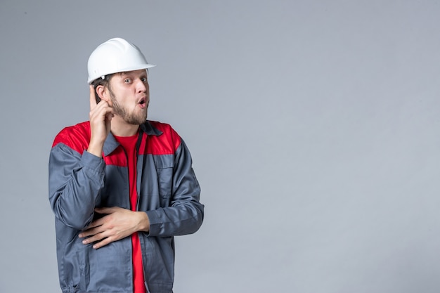 front view male builder in uniform on light background