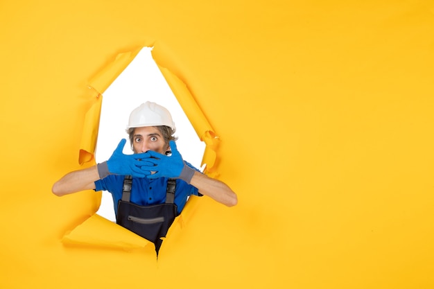 Free photo front view male builder in uniform on a yellow background