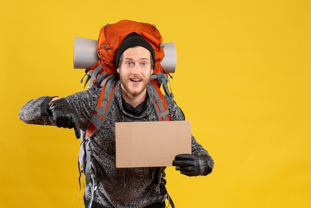 Free photo front view of male camper with leather gloves and backpack holding blank cardboard