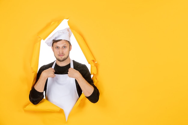 Free photo front view male cook in white cape and cap on yellow ripped food job color white man cuisine photo