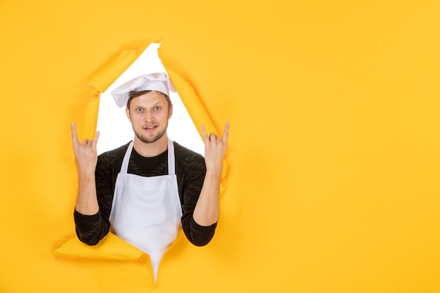 Front view male cook in white cape and cap on the yellow ripped job color white kitchen food man cuisine photo