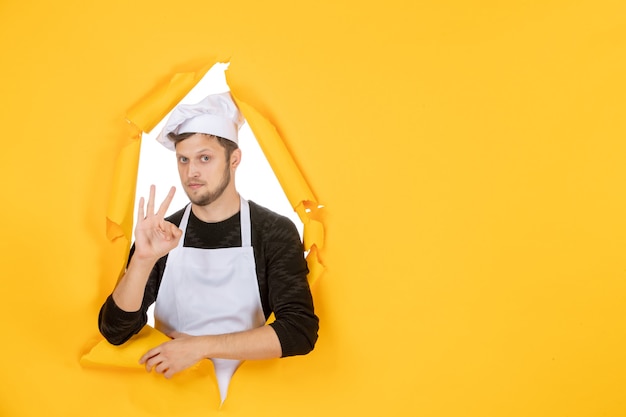 Front view male cook in white cape and cap on yellow ripped job color white kitchen man cuisine photo