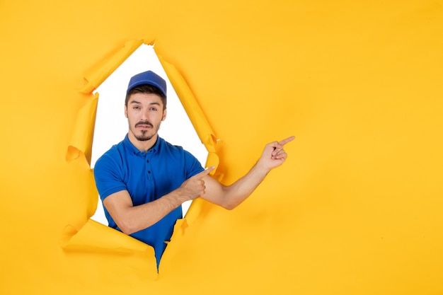 Front view male courier in blue uniform on the yellow space