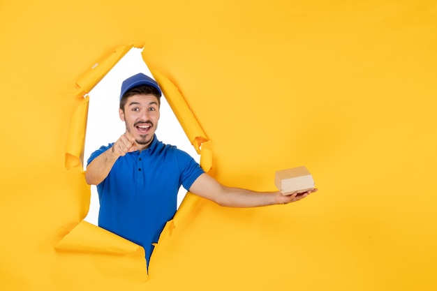 Front view male courier holding little food package on yellow space