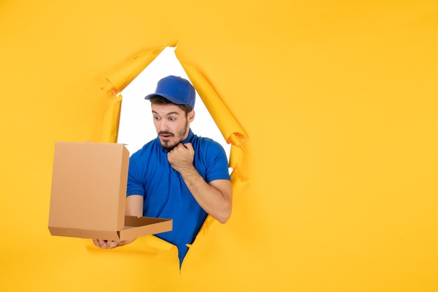 Free Photo front view male courier holding opened pizza box on yellow space